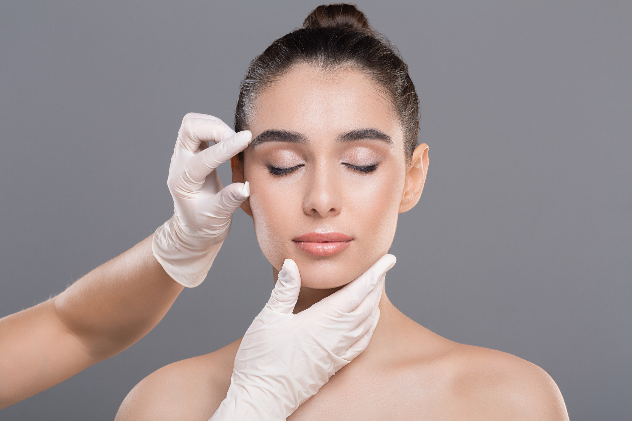 Illustrative photograph of a facial assessment with gloved hands