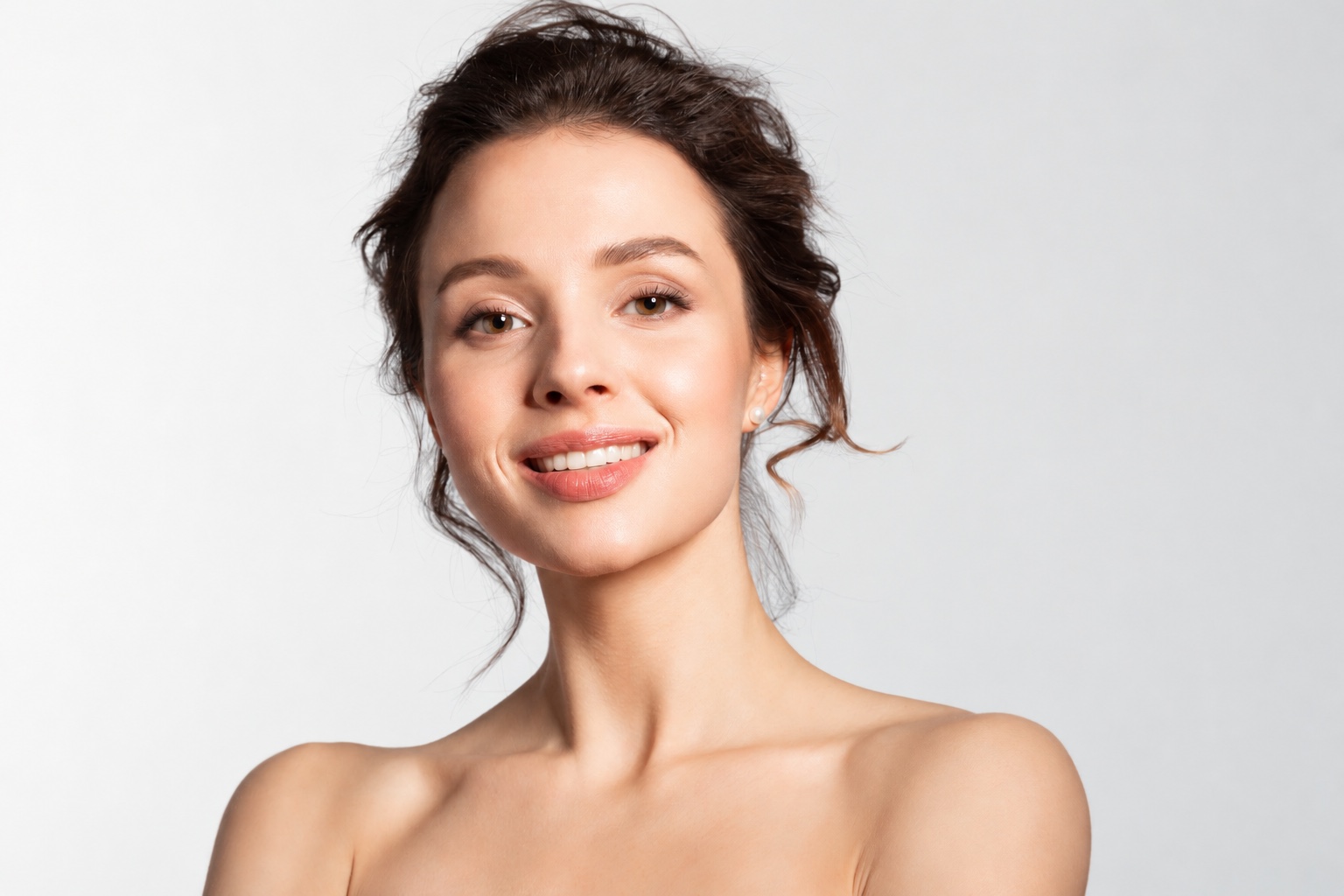 Smiling studio portrait against a soft neutral background